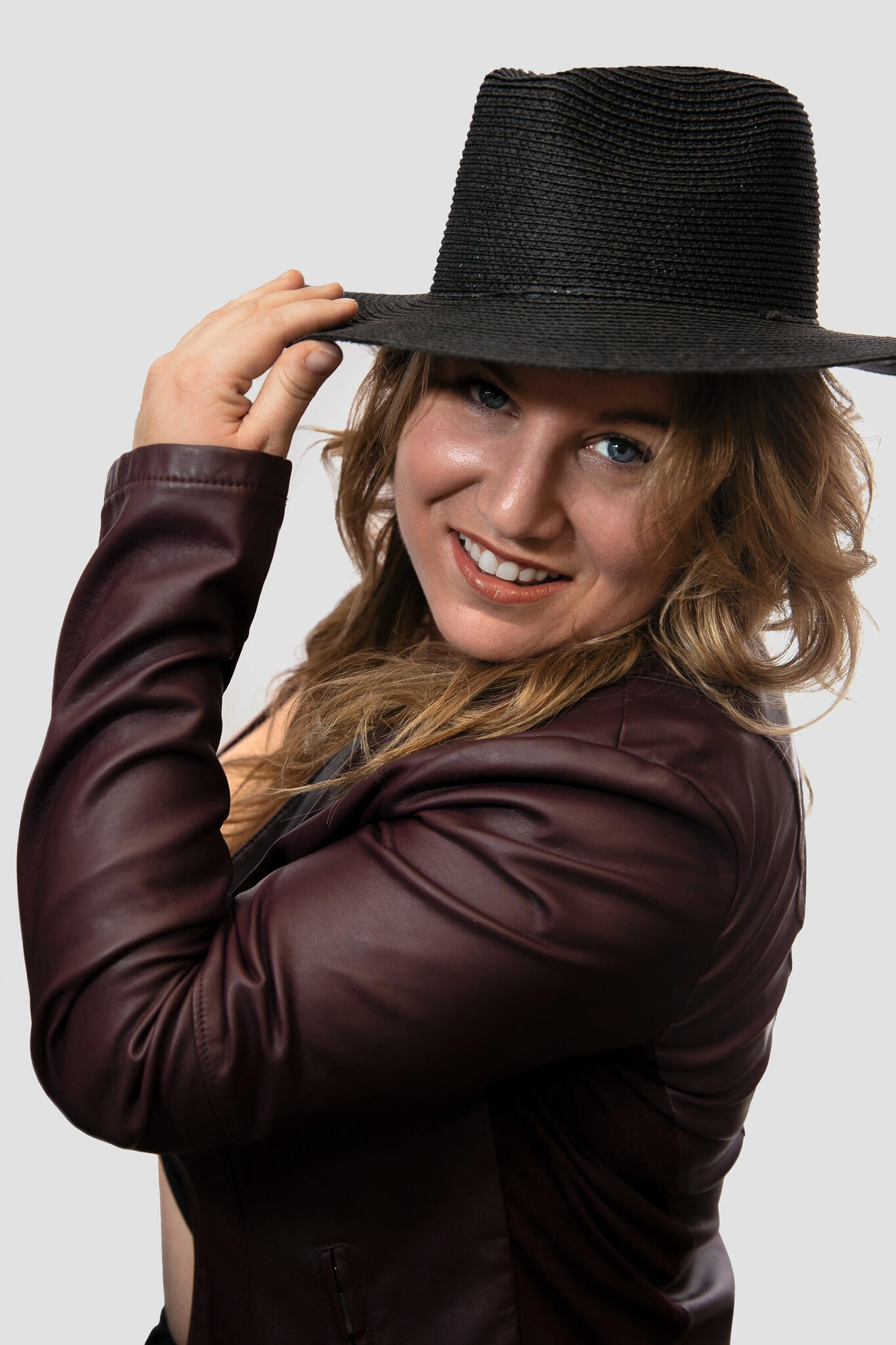 Photographe blonde avec un chapeau noir qui prend la pose